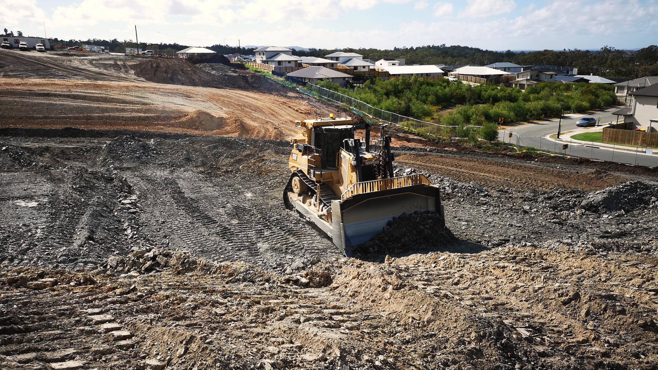 A Caterpillar dozer shaping lots during earthworks at Holmview Estate, Logan